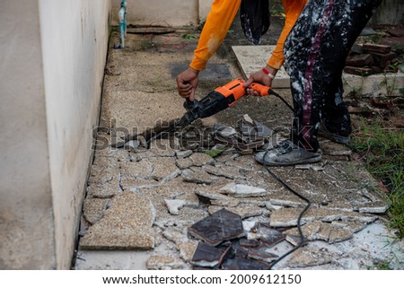 The demolition hammer drill is driving to the floor for using to drilling floor tile, cement. Floor during renovation construction.