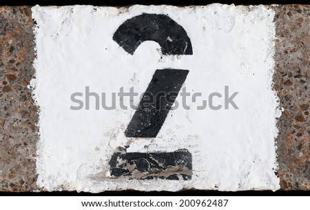 Painted abstract black number on painted white concrete background