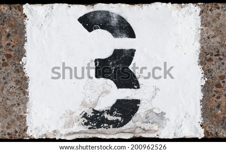 Painted abstract black number on painted white concrete background