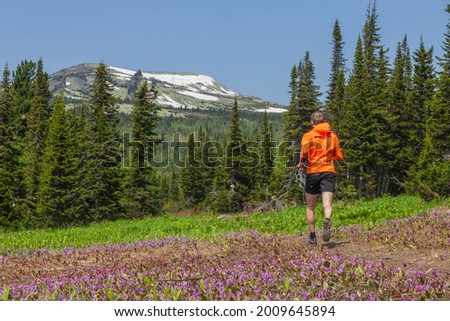 Young man doing a running workout in the mountains. Sheregesh, Russia