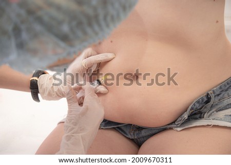 Lipotropic injections close up. Woman Belly fat dissolving treatment. Abdomen rabies vaccine. Royalty-Free Stock Photo #2009670311