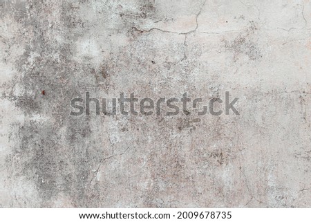 Grey concrete wall with natural defects. A fragment of a dilapidated wall with natural damage in the form of chips and roughness. Textured background for integration into the design.