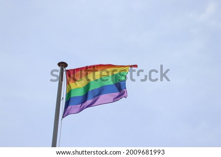 A rainbow gay pride flag on a tall flagstaff