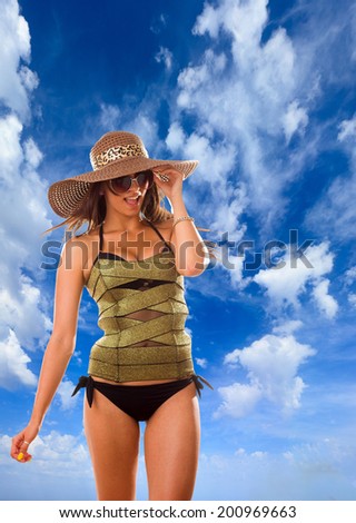 Young woman with straw hat and corset over sky background