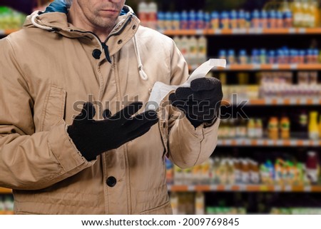 Closeup photo of shocked man looking at store receipt