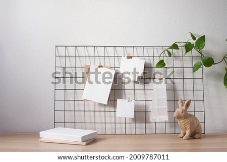 Cards and posters mock ups on black grid board. Blank paper in different sizes and color palette attached with binder. Craft paper rabbit. Template for prints, photography, to do or planning lists. 