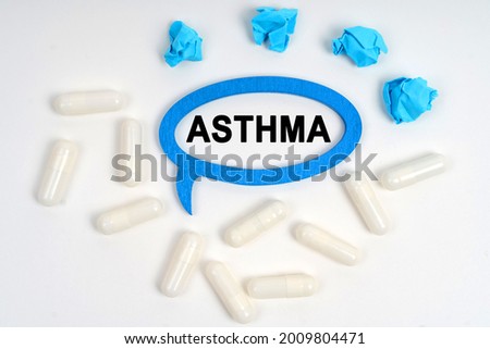Medicine concept. On a white background pills, crumpled blue pieces of paper and a frame-thoughts with the inscription - ASTHMA