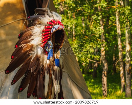 Feather headdress ancient amerindian . Attributes of the ancient american indian. Royalty-Free Stock Photo #2009826719