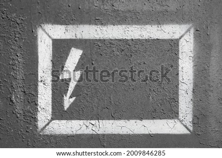 Dangerous high voltage sign in white frame on gray cracked wall