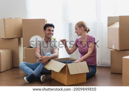 happy Caucasian couple sit on with stuff in boxes moving to new home. Adult men and women consult and plan for the future of their families. Family and real estate concept