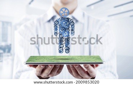 Close of businessman holdingn tablet pc with office worker figure. Mixed media