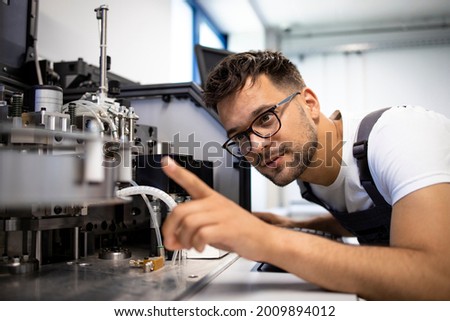 Mechatronics engineering in process. Experienced engineer working on new automated robotic machine. Royalty-Free Stock Photo #2009894012