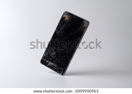 Mobile phone in equilibrium with a very broken screen and the circuitry coming out of the corners
