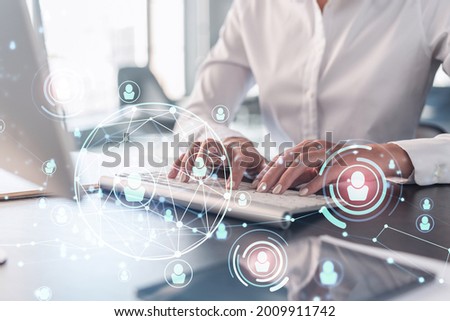 HR woman specialist is typing the keyboard in the internet to find the best candidates to create international network in recruitment process. Formal wear. Social media hologram icons. Royalty-Free Stock Photo #2009911742