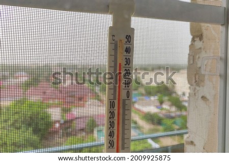 Outdoor thermometer with the temperature above 30 degrees