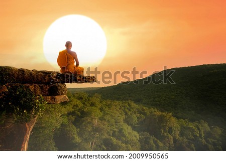 Buddhist monk in meditation at beautiful sunset or sunrise background on high mountain Royalty-Free Stock Photo #2009950565