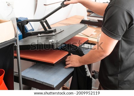 a unrecognizable person working on a iron sublimation. printing concept and graphic design.