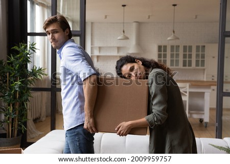 Tired millennial spouses exhausted of carrying heavy packages with belongings furniture at relocation day. Sad upset young family couple renters tenants leaving rented apartment when lease term is out Royalty-Free Stock Photo #2009959757