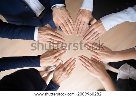 Different aged business team standing in circle, making circular shape of hands, open palms. Corporate coworkers engaged in teamwork activities for growing community motivation. Close up, top view