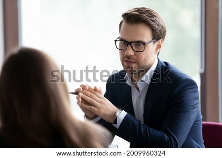 Serious male manager, lawyer, broker, talking to client, giving consultation, advice. Businessman, employer interviewing job candidate for hiring. Business leader in glasses meeting with employee Royalty-Free Stock Photo #2009960324