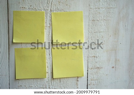 Blank sticky note pasted on a white wooden wall, can be used for various kinds of notes or reminders.                   