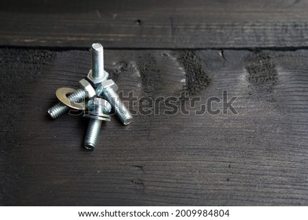 Silver bolt nut on black wooden table