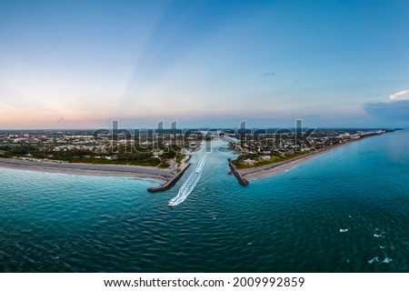 aerial view of jupiter inlet along florida atlantic coast in early morning with fishing boats headed out Royalty-Free Stock Photo #2009992859