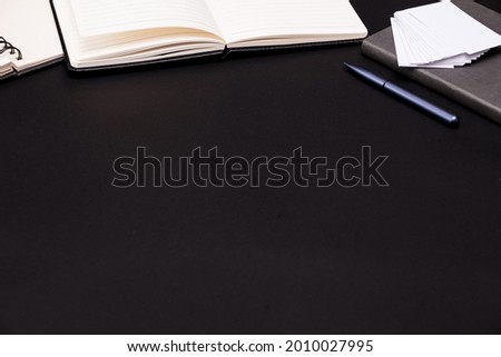 Flat lay of top view black work table with office objects includes copy space for add text or graphic, black background