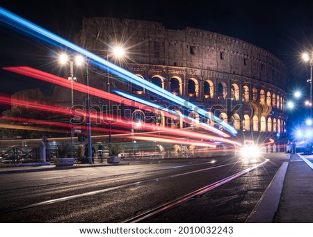 Colosseum at night Rome Italy with long exposure lights. Fast-moving traffic, bus cars. Royalty-Free Stock Photo #2010032243
