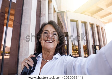 Selfie of hispanic mature businesswoman with modern background
