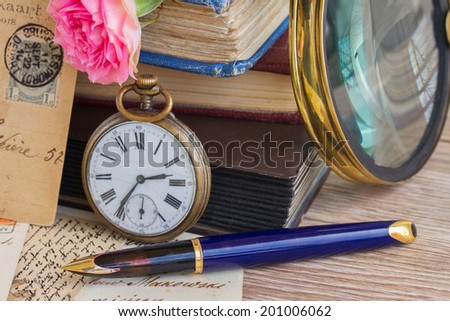 antique pocket  clock   on vintage  books and letters background