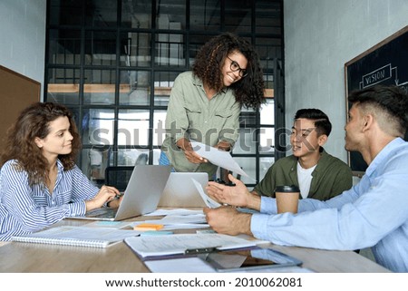 Diverse multiracial young happy cheerful coworkers business startup creative team people students discussing project results with African american mentor leader in contemporary office using laptops. Royalty-Free Stock Photo #2010062081
