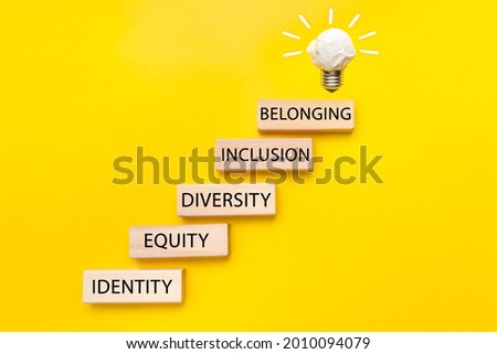 Equity, identity, diversity, inclusion, belonging symbol. Wooden blocks with words on beautiful yellow background. Inclusion, belonging concept. Royalty-Free Stock Photo #2010094079