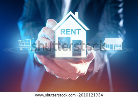 Renting business. Rent logo in front of businessman. Virtual screen with Renting business symbols. Home rental business. Investor in suit in background. Realtor controls tablet in front of him