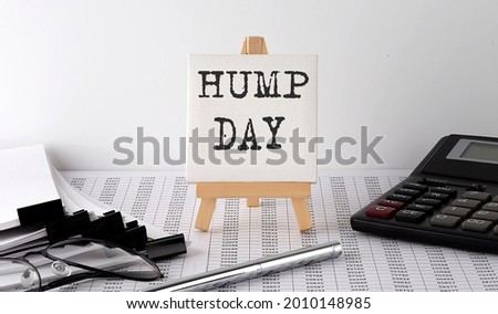 text HUMP DAY on easel with office tools and paper.Top view. Business