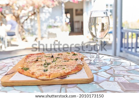 Mouth watering pizza made by indie chef with a good serving of white wine to really complete the meal. 