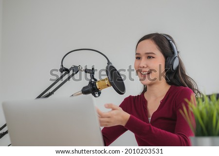 Beautiful asian young woman radio host working in headphones, microphone while talk, conversation and recording podcast, live on social media.Technology of on-air online in broadcasting at studio.