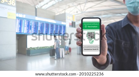 Traveler shows health passport of vaccination certification on mobile phone at international airport, to certicy that have been vaccinated of coronavirus covid-19