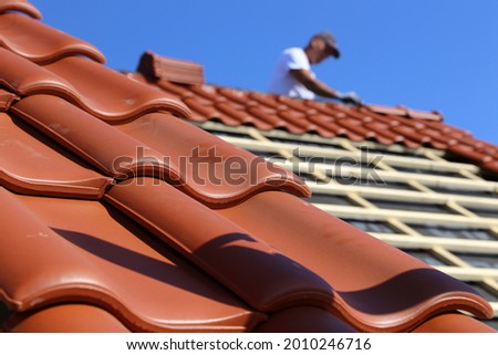 Roofing work, new covering of a tiled roof Royalty-Free Stock Photo #2010246716