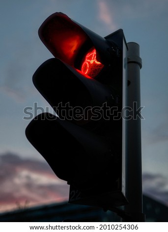 A close-up evening photo of a traffic light showing red light for cyclists