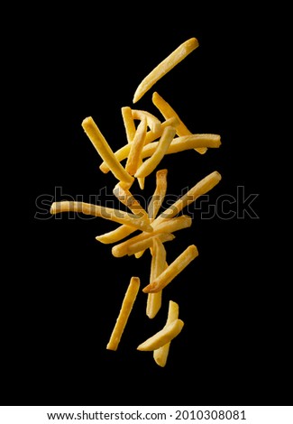 French fries - fried potatoes flying. Fly fastfood isolated on black background. Royalty-Free Stock Photo #2010308081