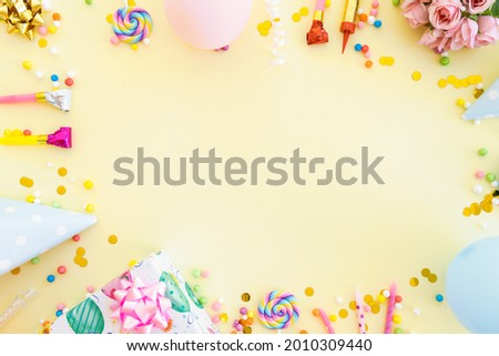 Frame of different party items and decorations with space for text on yellow background, flat lay Royalty-Free Stock Photo #2010309440