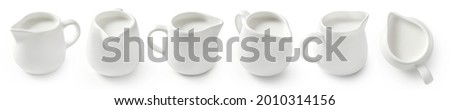 Set of porcelain milk jars isolated on white background. Milk pitchers for package design. Collection of ceramic milk creamers on white. Top view of milk. Royalty-Free Stock Photo #2010314156