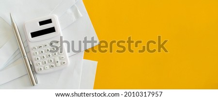 close up top view on calculator and open over group of invoice letter mail from  bank on yellow background for money and debt  management concept Royalty-Free Stock Photo #2010317957