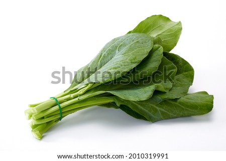 Bundle of water drops on fresh Chinese kale vegetable on white background