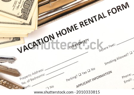 Mortgage and rental housing real estate application form. Vacation concept. House keys, money, top view  Royalty-Free Stock Photo #2010333815