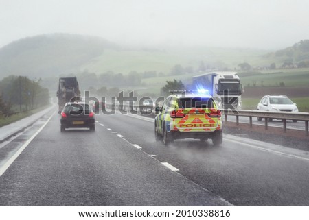 Police siren flashing blue lights driving on motorway to accident or crime scene Royalty-Free Stock Photo #2010338816