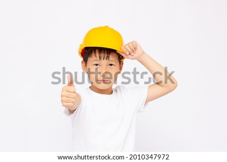 Cute kid while wearing construction helmet, isolated on white background