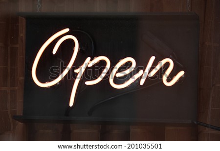 A neon open sign in the window of a store