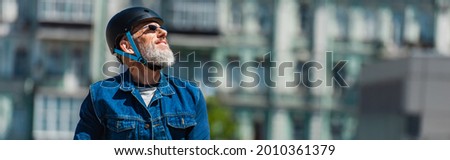 pleased man in sunglasses and helmet in urban city, banner
